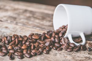 Coffee beans spilling from a mug